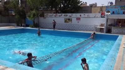  Aşırı sıcaklarından bunalan gençler havuzda serinliyor