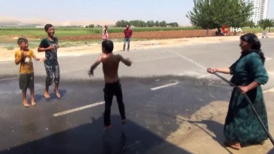 su -  Sıcaktan bunalan çocuklarını hortumla su sıkarak serinletti Videosu